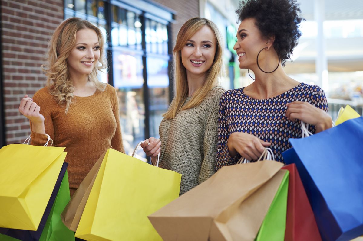 Amigas aproveitam a Black Friday para fazer compras em shopping center