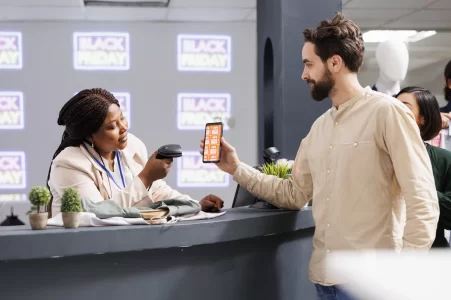 Vendedora de quiosque de shopping apresenta produto a cliente