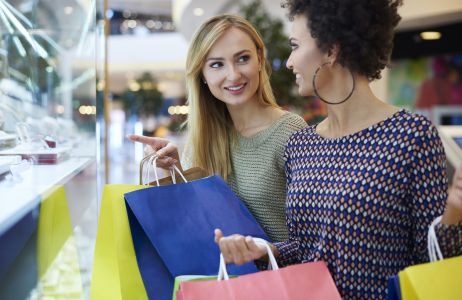 Mulheres observam publicidade em shopping center