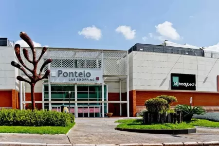 Fachada principal do Ponteio Lar Shopping com entrada envidraçada e paisagismo ao redor.