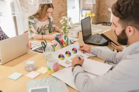 pessoas trabalhando em uma mesa fazendo plano de marketing - plano de marketing