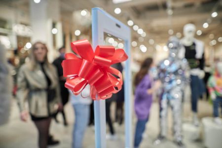 Decoração de inauguração de loja em shopping com laço vermelho em destaque, criando um ambiente festivo e acolhedor para os clientes.