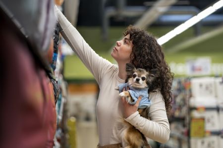 Mulher segura cachorro e faz compras em Shopping pet friendly