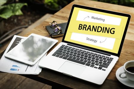 notebook e outros dispositivos eletrônicos em uma mesa de madeira para pesquisas sobre ativação de marketing